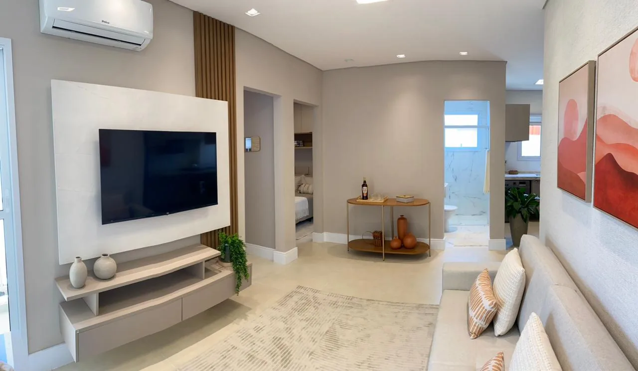Painel branco de TV com ripado de madeira e corredor para os quartos